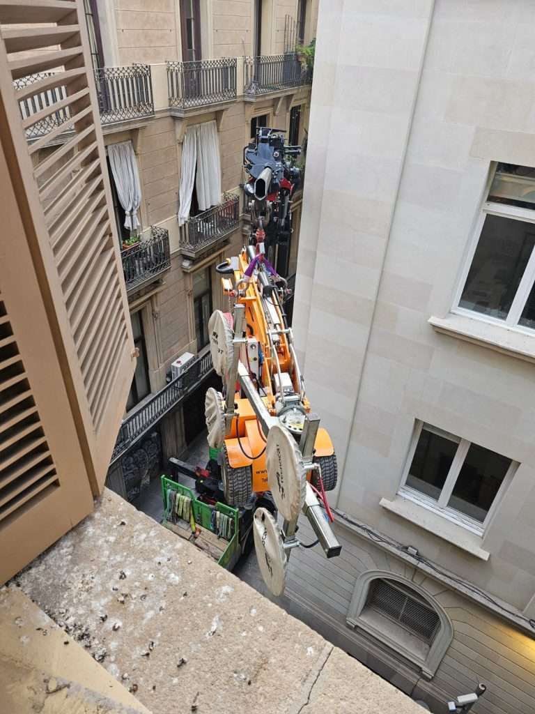 Camión grúa y robot acristalador de Grúas Junfe trabajando en Barcelona