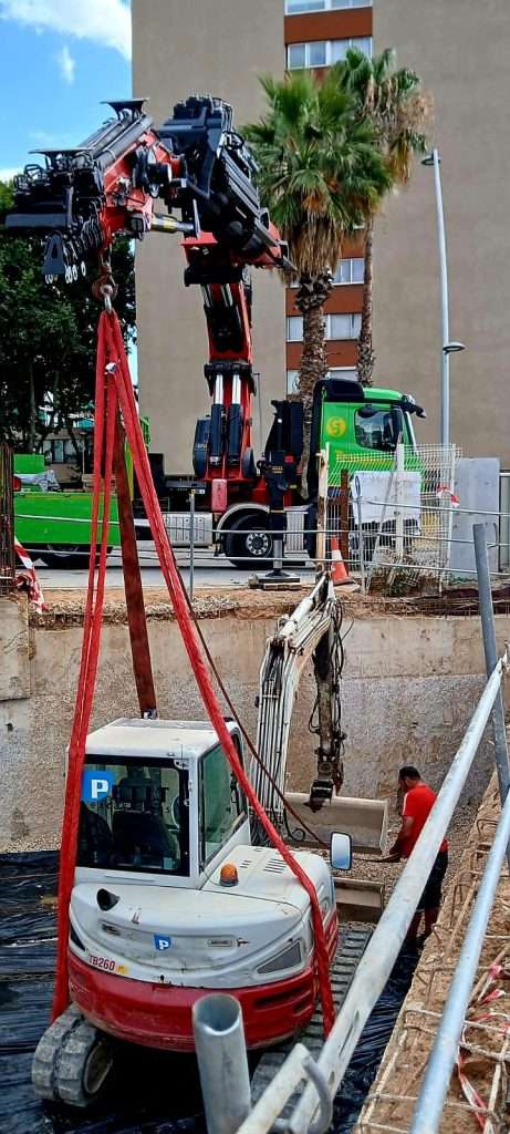 Camión grúa de Grúas Junfe en operación de elevación en calle.