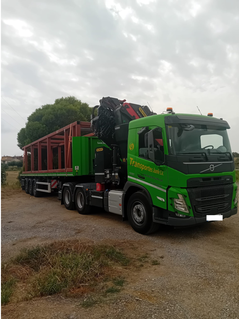 Camión grúa con estructura metálica lista para ser descargada.