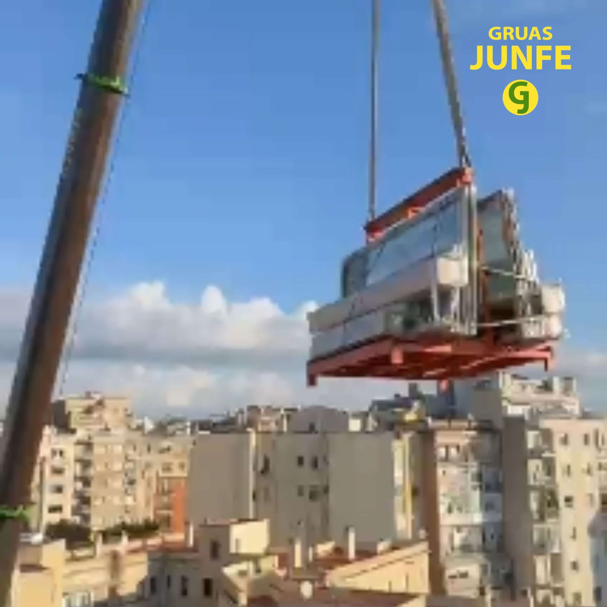 Grúa elevando módulo de ventanales sobre la ciudad de Barcelona
