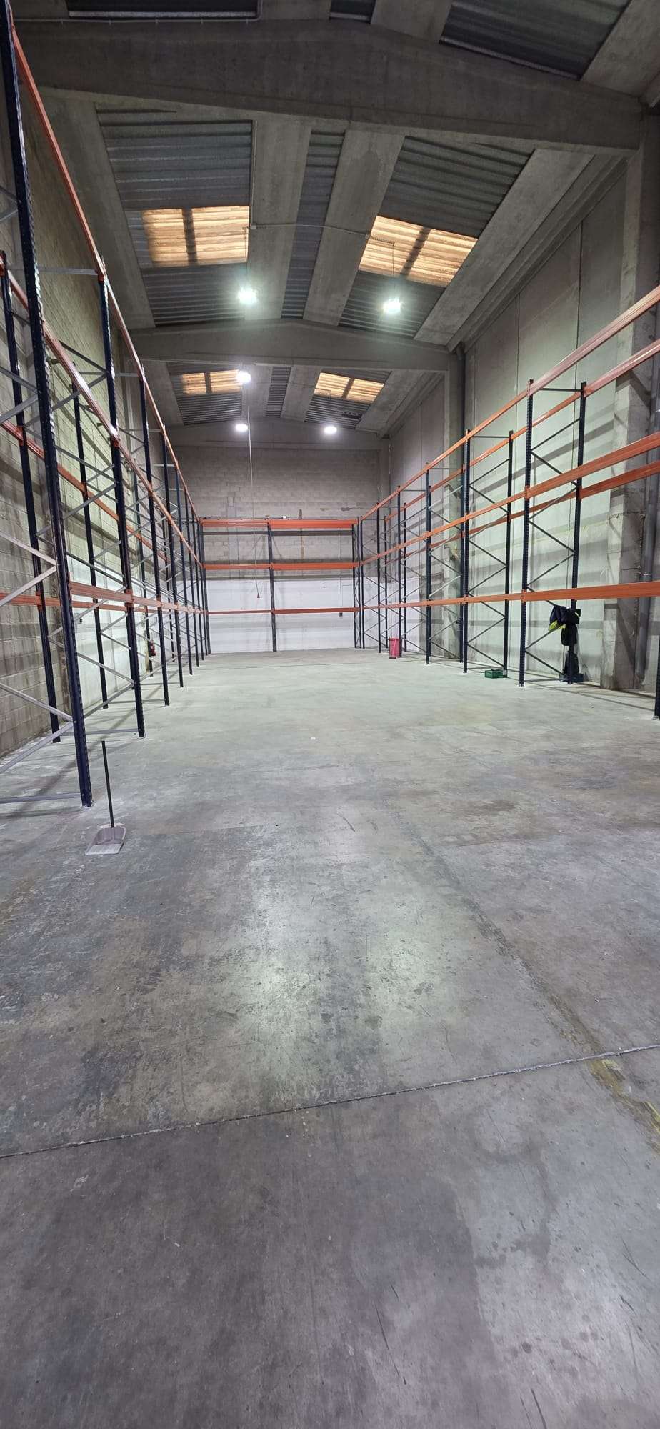 Interior de la nueva nave logística de Grúas Junfe con estanterías de almacenamiento.
