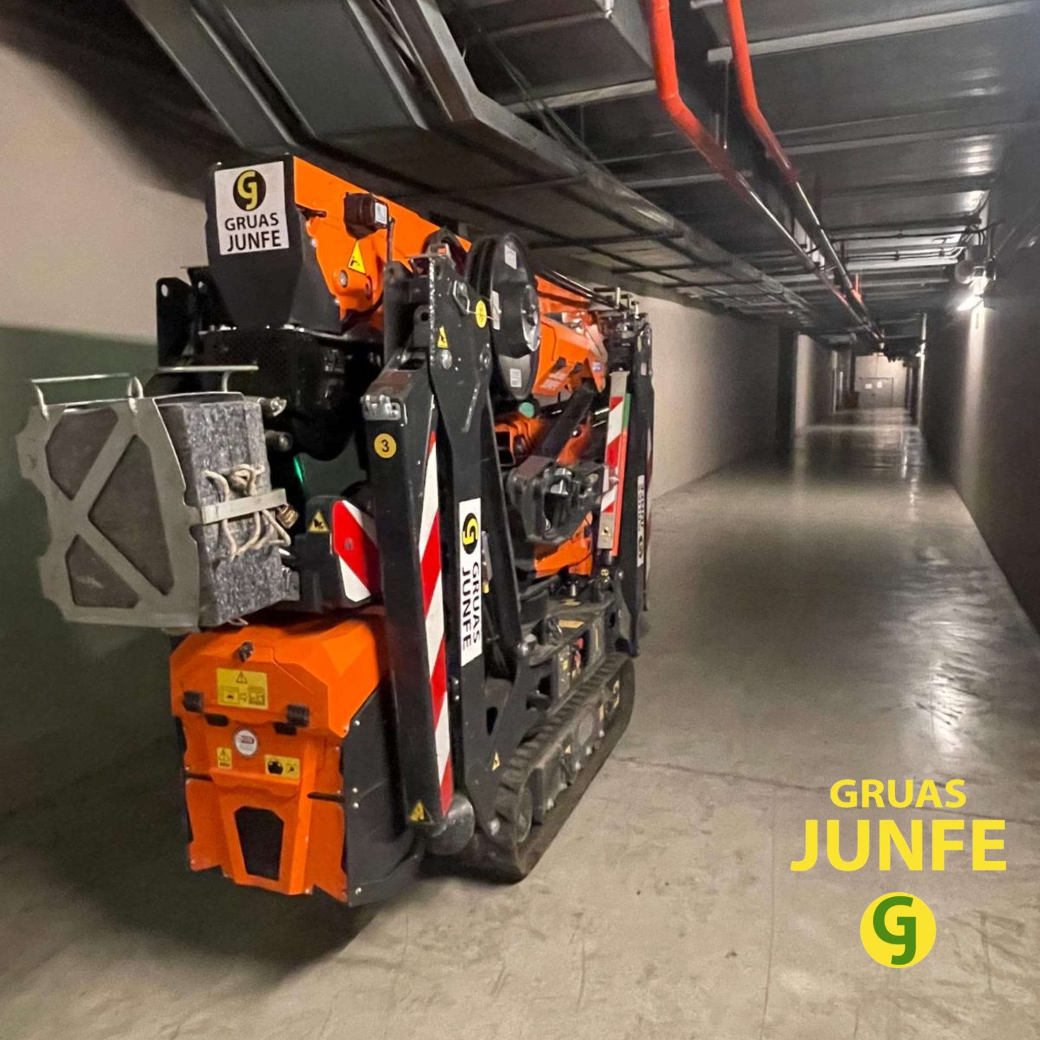 Minigrúa articulada de orugas Jekko de Gruas Junfe circulando por pasillo técnico subterráneo.